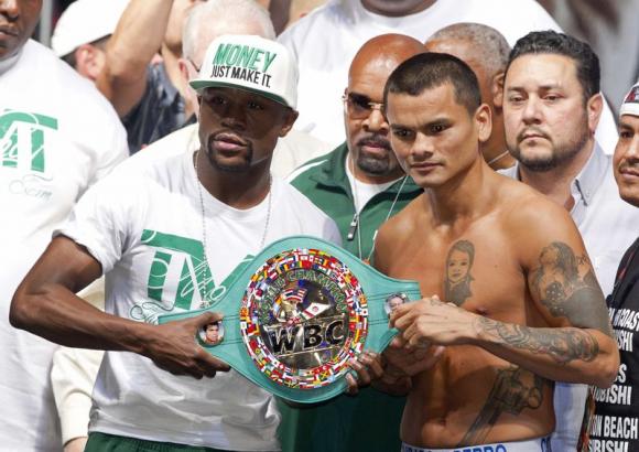 Floyd Mayweather Jr. and Marcos Maidana pose with the WBC belt during their official weigh-in at the MGM Grand Garden Arena in Las Vegas
