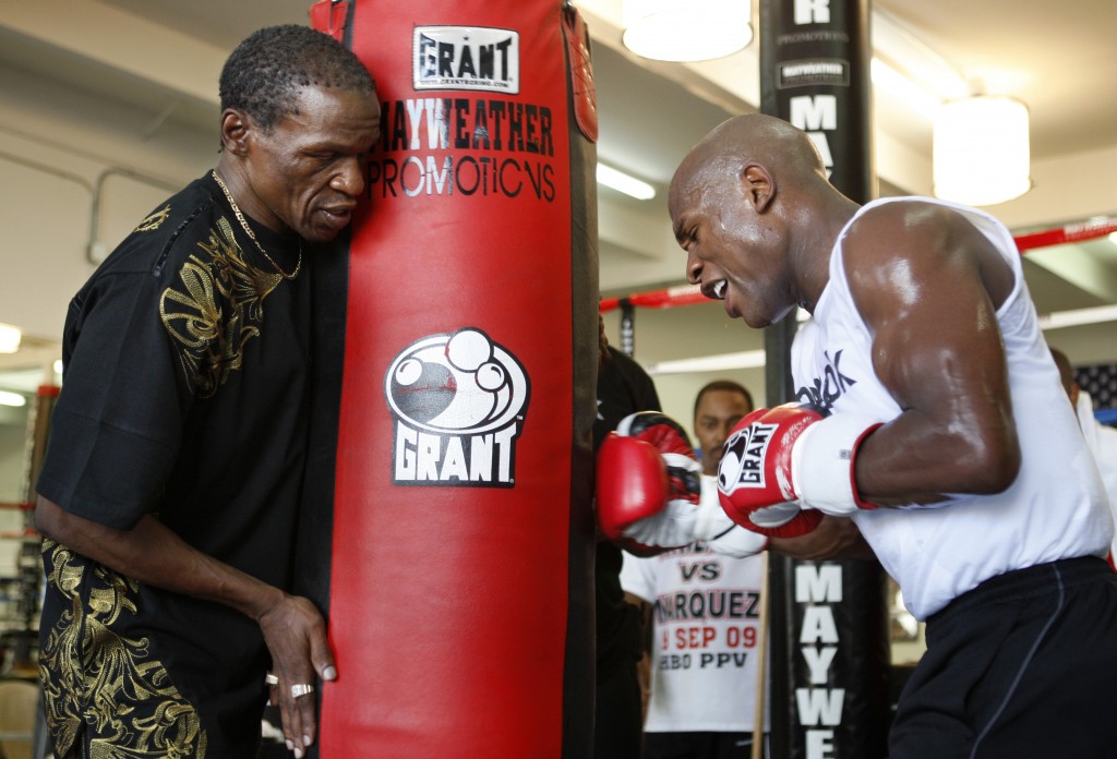 Floyd Mayweather Sr. holds a heavy bag for his son Floyd Jr. of the U.S. during a media workout at the Mayweather Boxing Club in Las Vegas